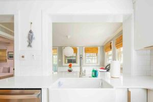 a white kitchen with a sink and a counter at Hip Island House in Charleston