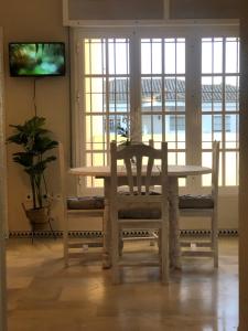 a dining room with a table and two chairs at Calma La Barrosa Apartamento in Chiclana de la Frontera
