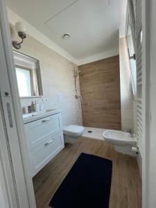 a white bathroom with a sink and a toilet at The Plus #3 HOWME in Bari +5 photos