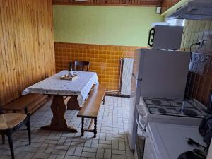 uma pequena cozinha com uma mesa e um frigorífico em chez Jean-Marc et Colette em Le Molay-Littry