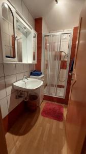 uma casa de banho com um lavatório branco e um chuveiro em Spulhof em Abtenau