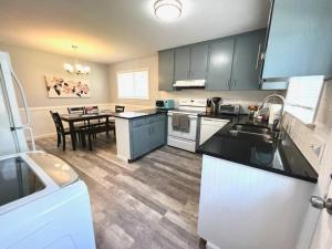 a kitchen with blue cabinets and a table in it at *Comfortable Townhome * King Beds * Long Term* in Cary +8 photos