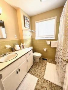 a bathroom with a sink and a toilet and a window at *Comfortable Townhome * King Beds * Long Term* in Cary