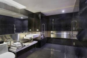 a black bathroom with a sink and a toilet at Hotels Here - Taipei in Taipei