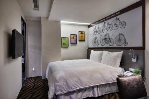 台北市にあるHotels Here - Taipeiのベッドルーム1室(ベッド1台付)、壁に自転車が備わります。