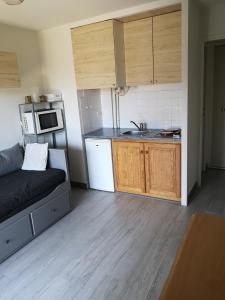 a small kitchen with a couch in a room at Ryo Beach in Courseulles-sur-Mer