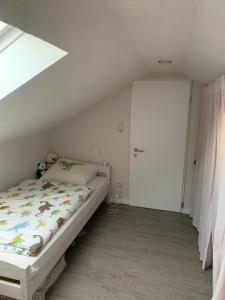 Habitación pequeña con cama y puerta en Lotta's Ferienhäuschen, en Emden