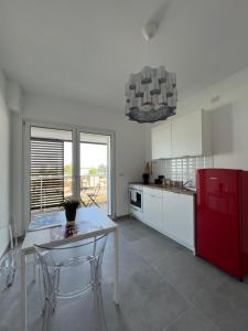 a kitchen with a table and a red refrigerator at The Plus #4 HOWME in Bari