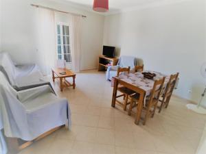 ein Wohnzimmer mit einem Esstisch und Stühlen in der Unterkunft Vivenda para férias (Algarve) in Manta Rota