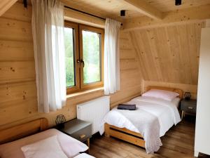 2 Betten in einem Zimmer mit Fenster in der Unterkunft Domek Pana Jana in Zakopane