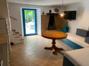 ein Zimmer mit einem Tisch und ein Wohnzimmer mit einem Sofa in der Unterkunft House Rozalia in Susak
