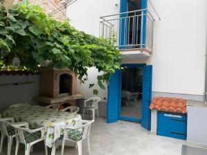 eine Terrasse mit einem Tisch, Stühlen und einer blauen Tür in der Unterkunft House Rozalia in Susak