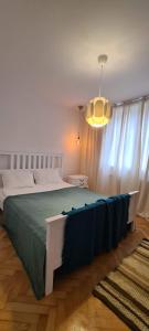 - une chambre avec un lit doté d'une couverture bleue dans l'établissement Ioana Apartment Resita, à Reşiţa