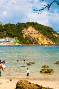 a group of people playing in the water at the beach at Apartamento inteiro em Morro de São Paulo- Flats Maré mansa in Morro de São Paulo