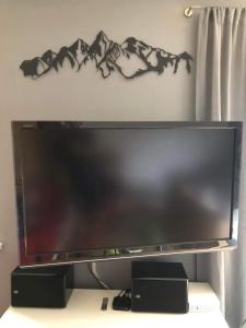 a large flat screen tv sitting on a stand at Bike - Apartament Ustroń Orzechowa 66 in Ustroń