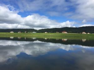 a large body of water with houses in the background at Brasel in La Brévine