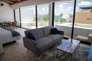 ein Wohnzimmer mit einem Sofa und einem Tisch in der Unterkunft Kiin Tulum, Luxury Suites in Tulum