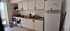 a kitchen with white cabinets and a refrigerator at Departamento126 in Junín