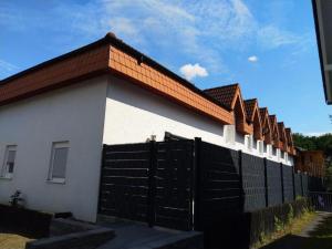 a white house with a black gate and a fence at Appartement Design 2 in Altenstadt