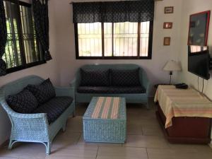 ein Wohnzimmer mit Sofas, einem Tisch und einem TV in der Unterkunft Villa Mar Sosua in Sosúa