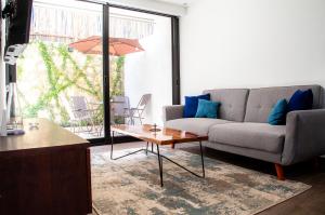 Kiin Tulum, Luxury Suites في تولوم: غرفة معيشة مع أريكة وطاولة