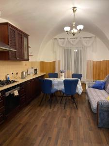 リヴィウにあるApartments on Virmenska Streetのキッチン、ダイニングルーム(テーブル、青い椅子付)