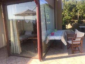 a patio with a table and an umbrella at Vervekis Apartments in Fiskardo