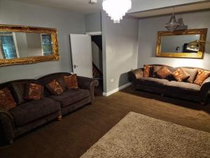 a living room with two couches and a mirror at Blackpool Home with Tower View in Blackpool