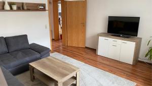 a living room with a couch and a flat screen tv at Alte Feuerwehr Bleicherode in Bleicherode