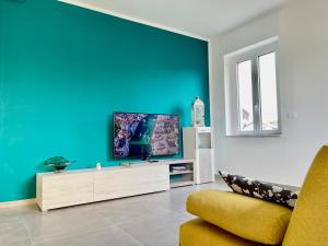 a living room with a tv on a blue wall at Villa Fiorita in San Maurizio Canavese