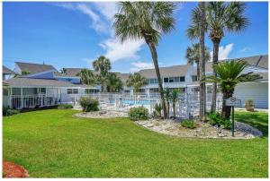 a house with a swimming pool and palm trees at New listing!!! 4 min walk to the beach! in Destin