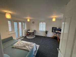 a living room with a couch and a tv at Aspen Villa in Hemel Hempstead