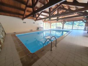 a large swimming pool in a large building at Pied des pistes, pleine nature in Ustou