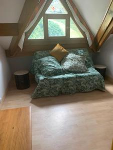 a bed sitting in a room with a window at Pleine nature Piscine chauffée in Ustou
