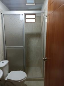 a bathroom with a toilet and a glass shower at Hotel Las Palmas de Puente Nacional in Puente Nacional
