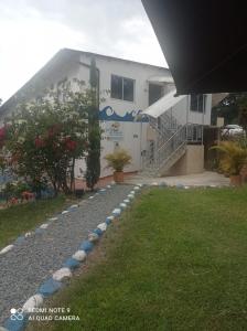 a building with a walkway in front of a yard at Hotel Las Palmas de Puente Nacional in Puente Nacional