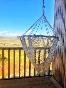 a hammock hanging on a porch with a view of the desert at Beautiful cottage with Mountain View in Fludir
