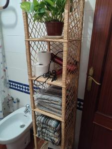 ein Bambus-Regal in einem Badezimmer mit Handtüchern und einer Pflanze in der Unterkunft Casa Alpujarreña Fina Número 27 in Bubión