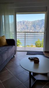 - un salon avec un canapé, une table et une grande fenêtre dans l'établissement Ancora Prcanj, à Kotor