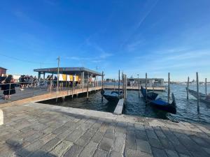 a dock with several gondolas in the water at Ca' ai Sospiri in Venice