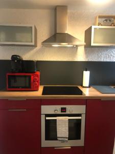 a kitchen with a stove and a red microwave at Suites Residences Spa in Colmar