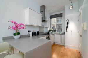 a kitchen with white cabinets and a white counter top at GuestReady - Stunning Covent Garden 2BR Duplex in London