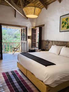 um quarto com uma cama grande e uma varanda em El Albergue Ollantaytambo em Ollantaytambo