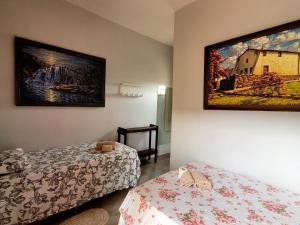 a room with two beds and a painting on the wall at Atelier & Pousada Chapada in Alto Paraíso de Goiás