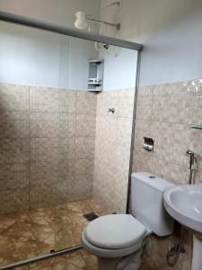 a bathroom with a shower and a toilet and a sink at Atelier & Pousada Chapada in Alto Paraíso de Goiás