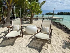 duas cadeiras e uma mesa numa praia em ONLY YOU MOTU em Bora Bora