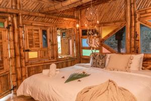 a bedroom with a bed in a wooden cabin at Ecohotel Tierra de Agua in Cocorná