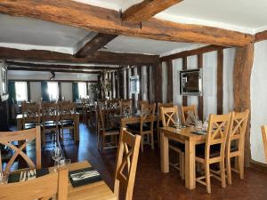 a dining room with wooden tables and chairs at The Hole In The Wall in Little Wilbraham
