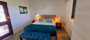 um pequeno quarto com uma cama e um banco azul em Villa Carina Apartments em Kralendijk