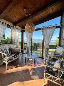 a living room with rocking chairs and large windows at Complejo Rural Lar de Vies in A Pontenova